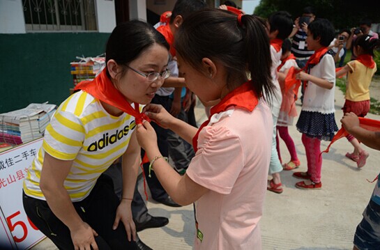 捐贈儀式上，孩子們?yōu)閻坌奶焓瓜瞪霞t領(lǐng)巾