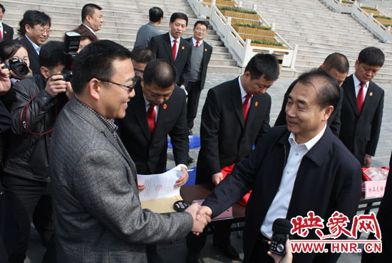 在新密市法院，省高院院長張立勇為拍得轎車的陳先生發(fā)放車鑰匙。