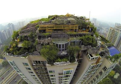 　　昨日，身穿橘黃色馬甲的工作人員在人濟(jì)山莊樓頂拆除違章建筑。新京報(bào)記者 吳江 攝