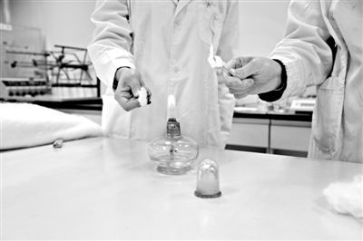 實驗人員操作的燃燒檢測法中，真蠶絲離開火焰就熄滅(左)。