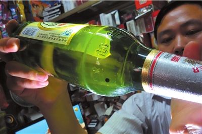 這瓶未開(kāi)封的燕京啤酒內(nèi)有一顆黑色懸浮物。京華時(shí)報(bào)記者 徐曉帆 攝