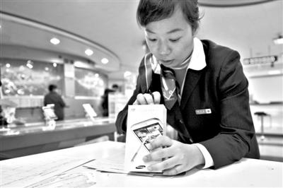 11月6日，北京移動(dòng)西直門營(yíng)業(yè)廳的工作人員在為顧客購(gòu)買的4G手機(jī)登記。新華社發(fā)