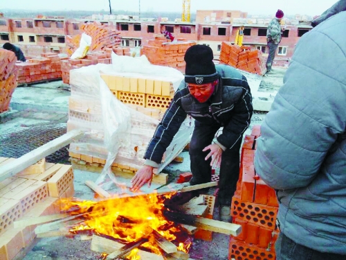 在俄羅斯工地打工時(shí)，因?yàn)樘焯?，工人不得不在工地生火取暖。（圖由方先生提供）