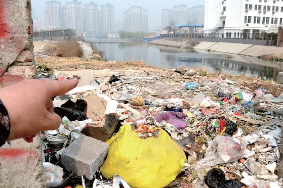 金水河長江路橋下河水發(fā)臭，水邊堆放眾多垃圾