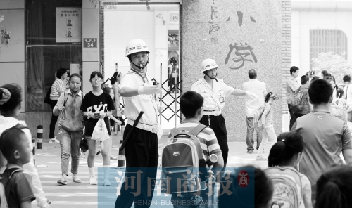 伊河路小學(xué)門口，兩名巡防隊(duì)員護(hù)送學(xué)生過馬路