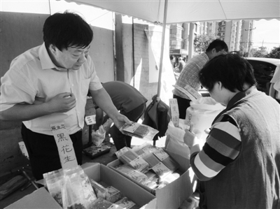 昨日，河南企業(yè)家劉春喜在京“練攤”，為顧客挑選綠豆。新京報記者 張玉學 攝