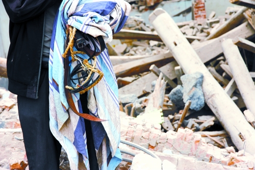 老人手中拿著曾控制住他的電線、床單