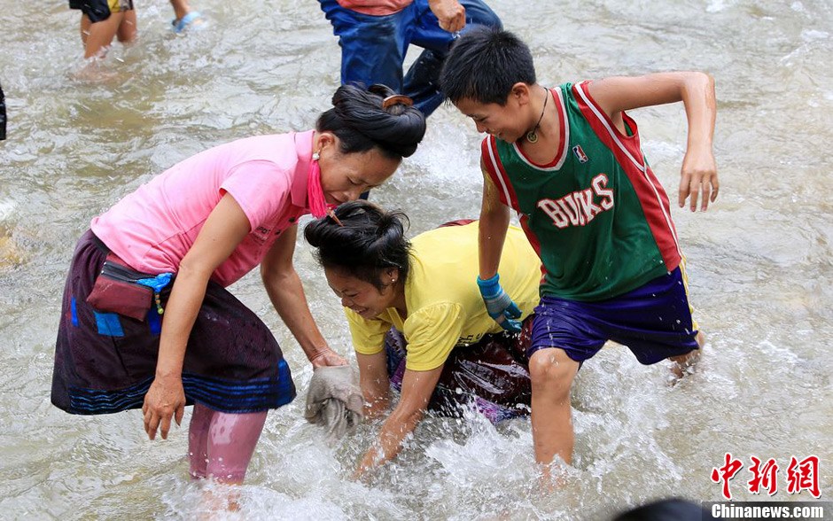 7月9日，村民在小河里摸魚搶魚。譚凱興 攝
