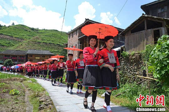 圖為新娘身著瑤族盛裝在伴娘和親友的陪伴下“出嫁”。中新社發(fā) 韋吉陽 攝