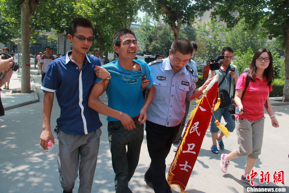 圖為獲救嬰兒父親情緒一度失控，當(dāng)?shù)鼐焦ぷ魅藛T對(duì)其進(jìn)行攙扶。張一辰 攝