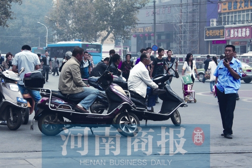 　火車站廣場北側(cè)，幾輛摩的正在等客
