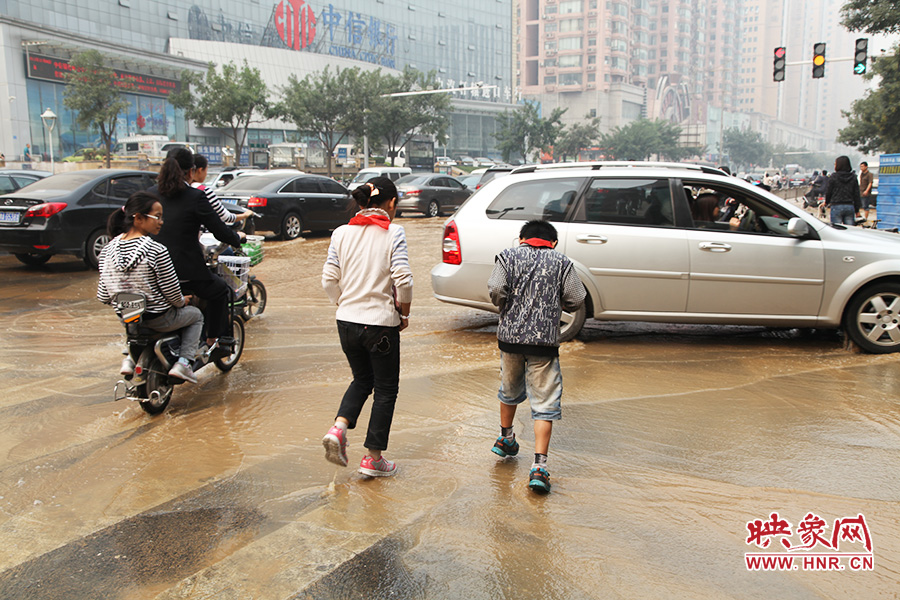 放學(xué)路過(guò)的學(xué)生在路口玩水嬉戲 放學(xué)路過(guò)的學(xué)生在路口玩水嬉戲