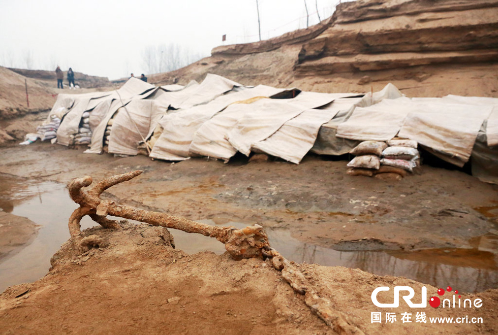 2014年1月6日，河南洛陽(yáng)古沉船發(fā)掘現(xiàn)場(chǎng)，古沉船鐵錨從見(jiàn)天日，靜靜地躺在古船旁。
