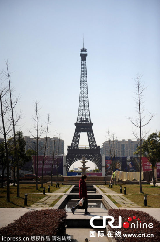 　2014年3月21日，杭州天都城，農(nóng)民在山寨埃菲爾鐵塔下耕作。圖片來(lái)源：東方IC