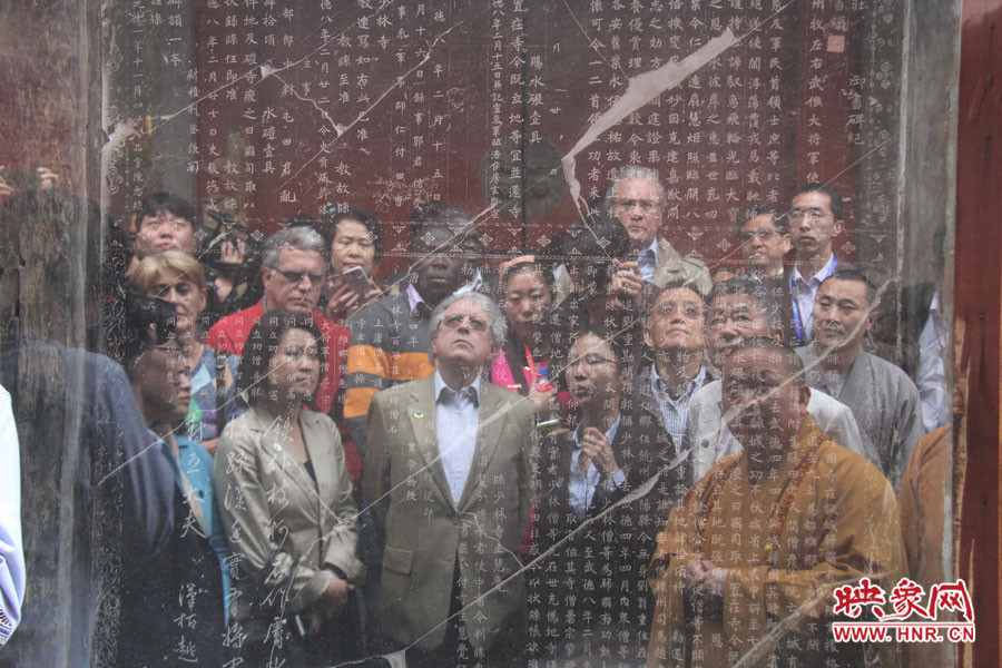 在一塊石碑前，少林寺方丈正在講解