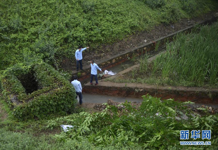 5月18日，工作人員在槽罐車泄漏現(xiàn)場(chǎng)附近的水渠邊查看情況。