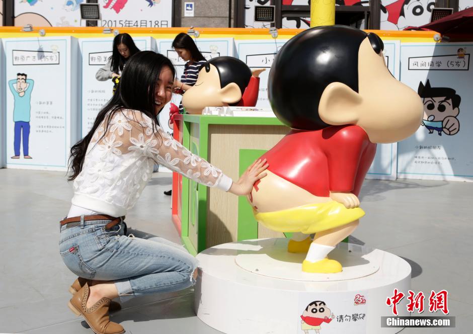 4月22日，游客與蠟筆小新合影。“蠟筆小新25周年紀(jì)念特展”日前在北京開(kāi)展，吸引了不少市民游客。