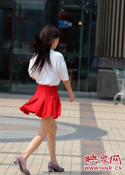 短裙美女在陽(yáng)光下匆匆而過(guò)