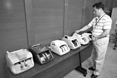 昨日，央行工作人員用各種驗(yàn)鈔機(jī)對C1F9假幣進(jìn)行測試，機(jī)器均能及時(shí)作出異常報(bào)警反應(yīng)。新京報(bào)記者 浦