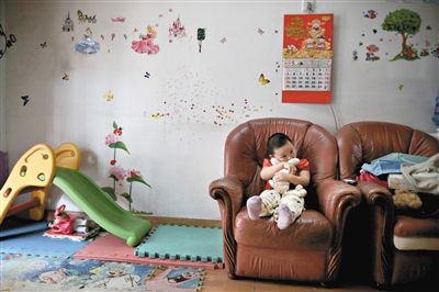 6月14日，未婚媽媽于軍的家里。女兒悅悅抱著兔子玩偶，在聽媽媽手機上的兒歌，這個4歲女孩喜歡兔子。