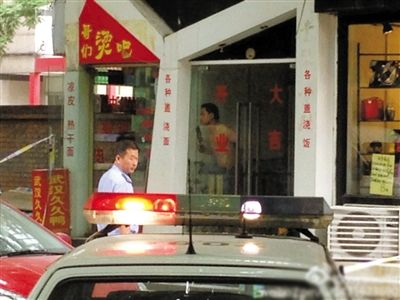 闖入面館的持刀男子與趕來的民警隔著玻璃門對(duì)峙，后店內(nèi)一名女童被其劫持。網(wǎng)友供圖