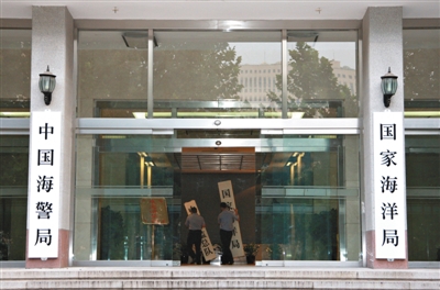 昨日，中國海警局掛牌成立。原國家海洋局和中國海監(jiān)總隊的牌匾被摘下，國家海洋局和中國海警局的新牌匾換上。黃冉 攝