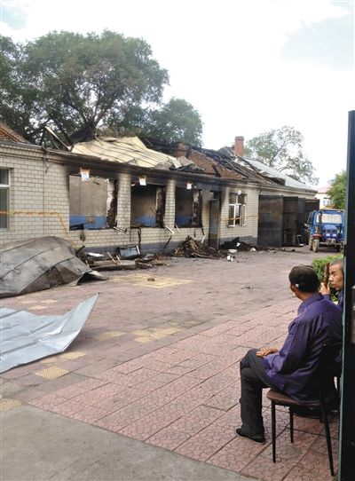 7月27日，海倫聯(lián)合敬老院內(nèi)，幾名老人看著對面被燒毀的特護(hù)病房。新京報(bào)記者 涂重航 攝