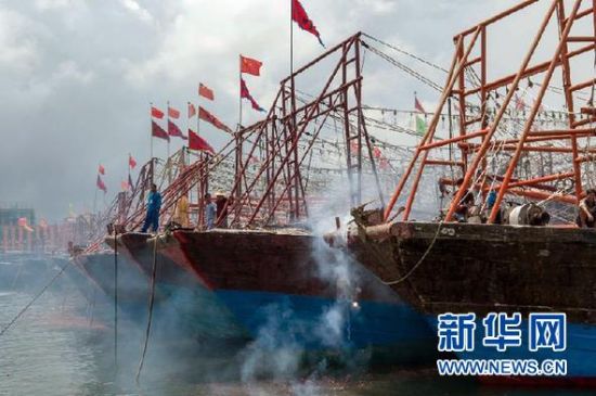 2013年8月1日 南海開漁日 臨高迎新港 8月1日，海南省臨高縣漁民在船上鳴放鞭炮慶祝武蓮港開港。