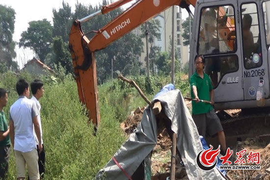 陳寶成手持自制刀斧守在挖掘機旁阻止便衣民警靠前。駕駛室內(nèi)，張朋珂正向受害人郭曉剛身上澆汽油。（視頻截圖）