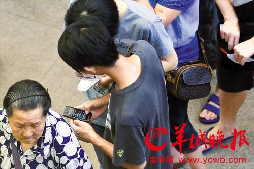 排隊的“黃?！备魇謭?zhí)一疊白紙，上面寫好了要掛號的人的信息，包括姓名、電話、要掛的科室等。穿黑白花紋衣服的老婆婆正在排隊掛號