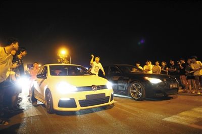 8月24日晚，東壩中街飆車現(xiàn)場(chǎng)，兩輛車并排等待出發(fā)指令，旁邊許多愛好者前來觀看比賽。新京報(bào)記者