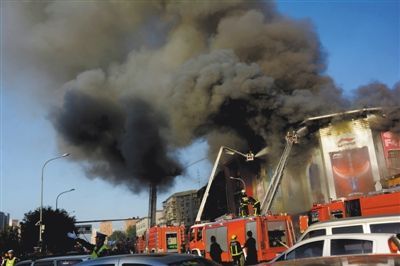 11日，蘋果園喜隆多商場，火災現(xiàn)場濃煙滾滾。新華社發(fā)