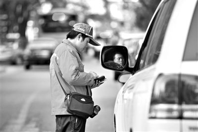 10月15日，朝陽區(qū)東大橋路，停車管理員從腰間掏出一個專用POS機，正在錄入停車信息。新京報記者 周崗峰 攝