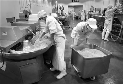 昨日，位于順義李遂開發(fā)區(qū)的慶豐包子鋪配送中心生產(chǎn)車間，工人們正在斬拌胡蘿卜餡料。