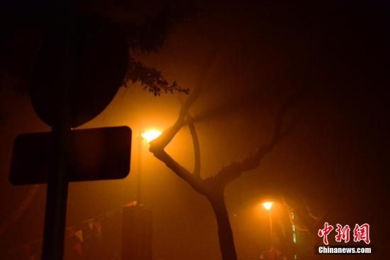 1月31日凌晨，市民行走在煙霧繚繞的南京街頭。當(dāng)天是農(nóng)歷馬年正月初一，南京有限開禁燃放煙花爆竹正逢下霧天，空氣的不流通致使煙花爆竹燃燒后產(chǎn)生的顆粒物不能及時(shí)散開，造成整座城市煙霧繚繞。據(jù)當(dāng)?shù)丨h(huán)保部門發(fā)布的信息顯示，空氣質(zhì)量屬重度污染。中新社發(fā) 泱波 攝