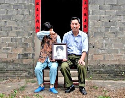 江蘇鎮(zhèn)江，老劉夫婦捧著獨(dú)生子的遺像在老家前留影南方都市報供圖L