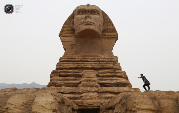 石家莊郊外，一名男子與山寨版獅身人面像合影留念。