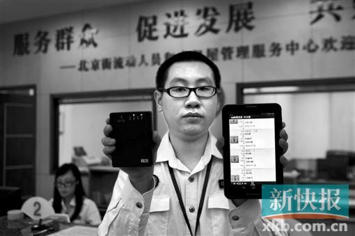 　越秀區(qū)北京街出租屋外來(lái)暫住人員管理服務(wù)中心的工作人員展示到出租屋登記來(lái)穗人員信息的儀器。