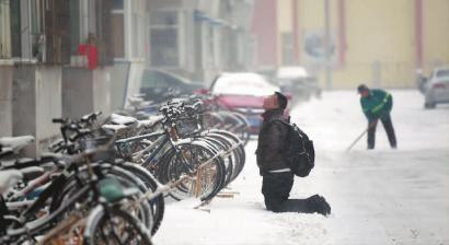 小伙子跪在樓前，一直抬頭看著樓上。 孫立國/攝