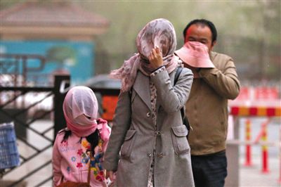 昨日下午，朝陽區(qū)豆各莊，行人將紗巾裹在頭上防沙塵。