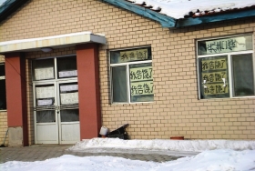 伊春市帶嶺區(qū)一排破舊的平房，房間窗戶上貼滿了“我告饒了”的字樣。