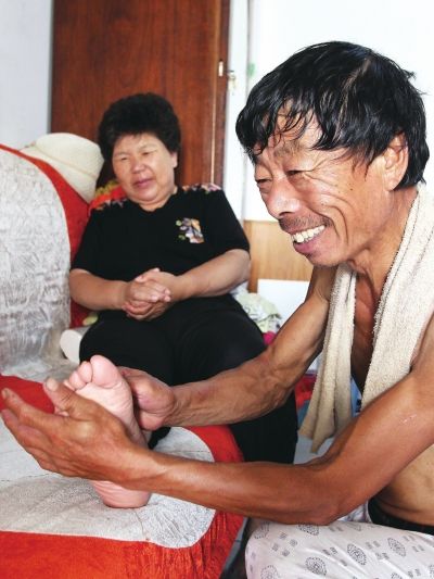 慈成富為老伴按摩。