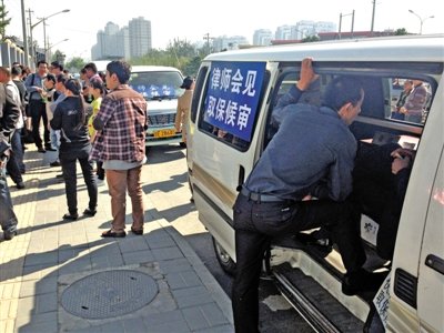 昨日，朝陽區(qū)看守所門前有人排隊。大門外還停有多輛寫有“律師會見”字樣的車。