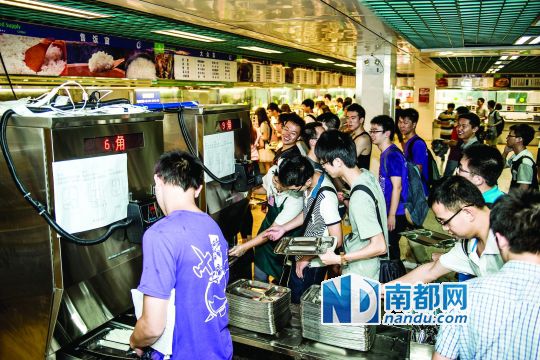 昨日，華南理工大學(xué)一食堂內(nèi)，學(xué)生們正在使用新安裝的自動打飯機打飯。中新社發(fā)