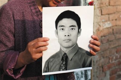 5月19日，朝陽(yáng)北路，母親捧著張東文的遺像。新京報(bào)記者 侯少卿 攝