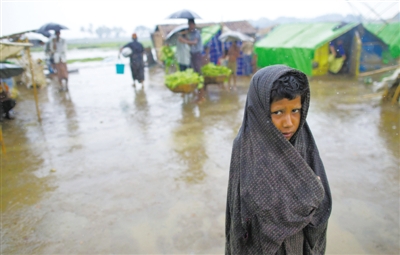 5月14日，緬甸若開邦實(shí)兌難民營，羅興亞族難民在雨中行走。熱帶風(fēng)暴“馬哈森”即將登陸緬甸，這里的難民開始乘船撤離。