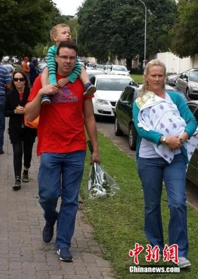 圖為一個白人家庭，由父母帶著孩子到曼德拉家門外悼念。中新社發(fā) 宋方燦 攝