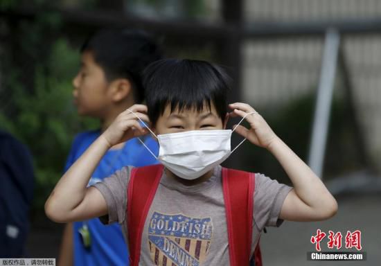 圖為當(dāng)?shù)貢r(shí)間2015年6月8日，韓國(guó)未停課的學(xué)校，學(xué)生課前戴口罩測(cè)體溫。