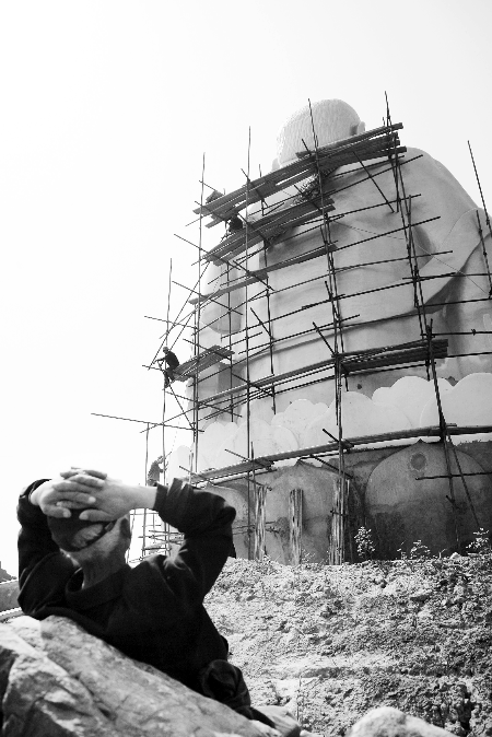 今年4月26日，工作人員將帆布蓋在“佛像”頭像上