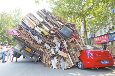 紅色小轎車被砸，卡在路邊動(dòng)彈不得。